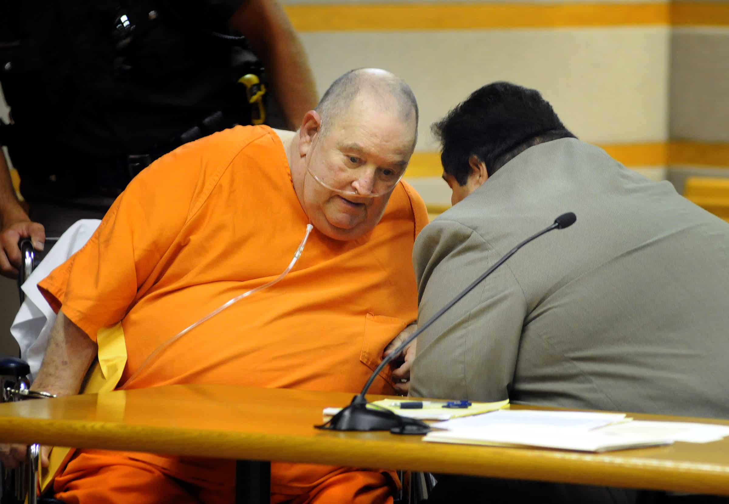 Edward Edwards confers with his lawyer while wearing orange prison attire during his trial